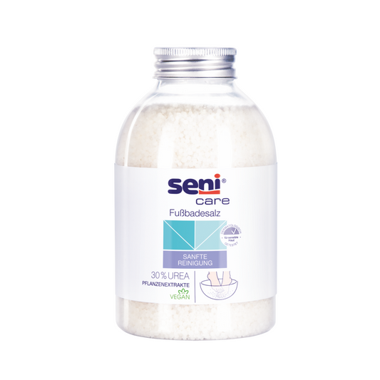 Das „Seni Care Badesalz für entspannende Fußbäder“ von TZMO Deutschland GmbH enthält weiße Salze mit Mineralstoffen und 30% Urea für eine sanfte, vegane Reinigung. Die Flasche mit silbernem Verschluss und Fußgrafik eignet sich perfekt für wohltuende Bäder.