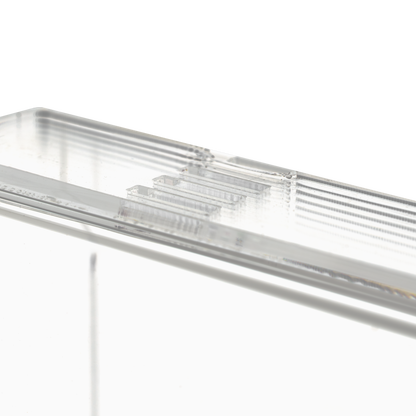 Nahaufnahme des transparenten, milchigen Einmalhandschuhs Spender (250 x 135 x 55-90 mm) der AMPri Handelsgesellschaft mbH, eines rechteckigen Acryl-Dispenserhalters mit geriffelten Kanten auf einfarbig weißem Grund.