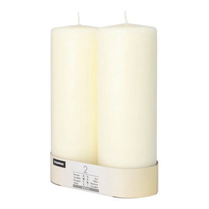 Dve neosvetlené Starpak 2 stĺpové sviečky Ø 80 mm s plochou hlavou stoja vedľa seba, na spodku sú obalené označenou páskou a vyžarujú nadčasovú eleganciu.