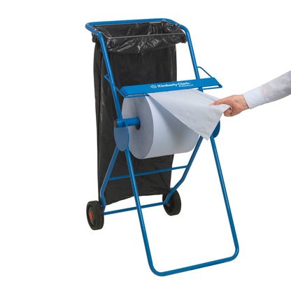 Ruka ťahá papierový uterák WypAll® L20 veľká rolka z veľkého modrého dávkovača Kimberly-Clark na kolieskach s čiernym odpadkovým vrecom, ideálny na údržbárske práce. 1 extra široká rolka x 1000 listov, modrá.