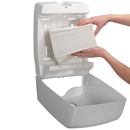 Osoba dopĺňa na stenu namontovaný dávkovač s Kleenex® Ultra™ skladanými uterákmi Interfold biele (15 klipov x 96 listov) od spoločnosti Kimberly-Clark GmbH a zabezpečuje hygienické sušenie rúk, pretože otvorený dávkovač umožňuje jednoduché dopĺňanie.