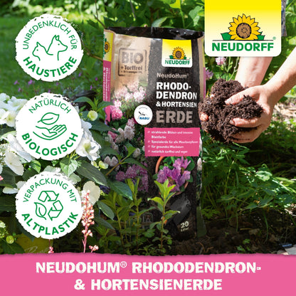 Osoba s bohatou NeudoHum Rhododendron & Hortensien Erde z Neudorff Shopu, ideálna na podporu zdravého rastu rododendronov.