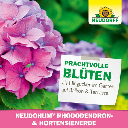 Detailný záber ružových a fialových hortenzií s etiketou, ktorá vychvaľuje "nádherné kvety" a propaguje NeudoHum Rhododendron & Hortensien Erde z Neudorff Shopu pre záhrady, balkóny a terasy.