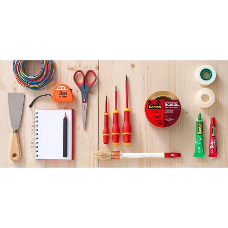 Rôzne nástroje a kancelárske potreby, vrátane držiaka 3M s pištoľovou rukoväťou + lepiaca páska Scotch na balenie (50 mm x 66 m, 1 dávkovač + 2 kotúče), nožnice, špachtľa, meracie pásmo, lepiace tuby, poznámkový blok s ceruzkou, drôty a štetce sú vystavené na dreve.