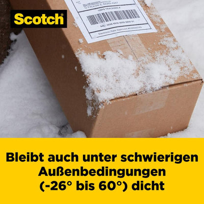 Zasnežený kartónový balík vonku ukazuje prepravný štítok. Text v nemčine znie: "Scotch® Box Lock™ baliaca páska 48 mm x 20,3 m od 3M Deutschland GmbH zostáva spoľahlivo tesná aj pri -26° až 60°.