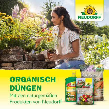 Eine Frau gärtnert und stellt Blumen in einen steinernen Pflanzkübel. Davor stehen Produkte des Neudorff Shop Azet Baum-, Strauch- & HeckenDünger, mit deutschem Text, der für organische Düngung für Ihren Garten mit natürlichen Neudorff-Produkten wirbt.