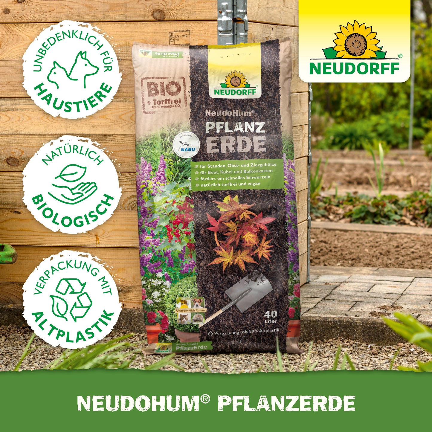 Ein Beutel NeudoHum PflanzErde aus dem Neudorff Shop steht aufrecht in einem Garten, perfekt für Stauden und Sträucher. Die Symbole zeigen, dass sie biologisch, tierversuchsfrei, torffrei und aus recyceltem Kunststoff hergestellt ist; das Neudorff-Logo befindet sich in der oberen rechten Ecke.