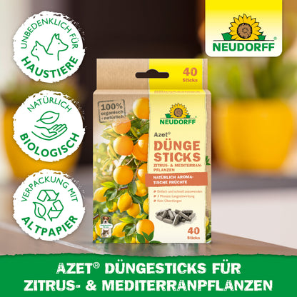 Abgebildet ist eine Packung Neudorff Shop Azet Düngesticks für Zitrus- & Mediterranpflanzen mit Symbolen für Tierschutz, Bio-Qualität und recycelbare Verpackungen. Im Hintergrund sind Zitronen und grüne Blätter zu sehen.