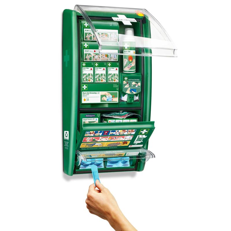 Stanica prvej pomoci a popálenín Cederroth od Orkla Wound Care AB je zelená, na stene namontovaná sada s označenými priehradkami na obväzy, bandáže a gél na popáleniny. Ruka vyťahuje modrú tkaninu z otvorenej jednotky, odhaľujúc usporiadané zásoby a jasné návody.