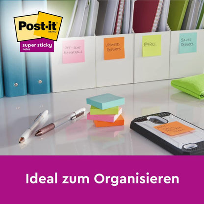Stôl s Post-it® Super Sticky Notes od 3M Deutschland GmbH (76 mm x 127 mm, 90 listov/blok, 100% PEFC), ktoré pomáhajú organizovať zložky ako "Mimopracovné materiály", "Aktualizované správy", "Výplatná páska" a ďalšie. Text: "Ideálne na organizovanie."