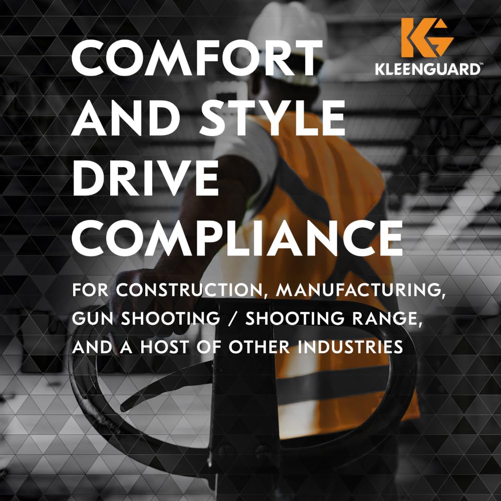 Eine Person mit Schutzweste und Schutzhelm steht neben einer Industrieausrüstung. Der eingeblendete Text wirbt für die KleenGuard® V30 Nemesis™ Schutzbrille mit Beschlagfrei-Beschichtung der Kimberly-Clark GmbH, die in einer Schachtel mit 12 transparenten Gläsern verkauft wird und für Komfort und Compliance sorgt.