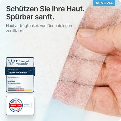 Eine Hand zieht eine durchsichtige Bandage von einem ARNOMED SUPERDRY PLUS Pad der ARNOWA GmbH ab. Der deutsche Text hebt den Hautschutz, die dermatologische Zertifizierung und die Qualitätsplaketten hervor, wobei das ARNOWA-Logo oben rechts zu sehen ist.