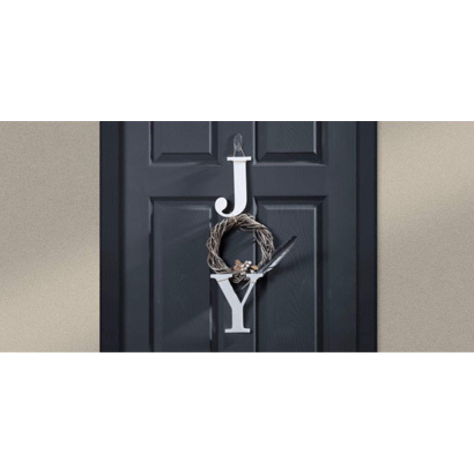An einer schwarzen Tür steht "JOY" senkrecht: Das "J" und das "Y" sind weiß, während das "O" ein Kranz mit einer kleinen Schleife ist, der mit einem 3M Command™ transparenten, ovalen Outdoor-Haken (17091AW, 1 Stück) der 3M Deutschland GmbH aufgehängt wurde.