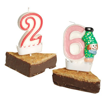 Červeno-biela "2" a ružovo-biela "6" číslicová sviečka s klaunom sú umiestnené na kúsky brownie, každá s držiakom na číslicové sviečky PAPSTAR (biely, 3,8x4,9 cm) ako stabilné, dekoratívne držiaky na narodeninové sviečky.
