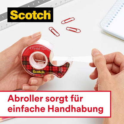 Osoba ťahá Scotch® Crystal lepiacu pásku, priehľadná, výhodné balenie (8 roliek, 19 mm x 33 m) od 3M Deutschland GmbH z červeno-kockovaného dávkovača. S kancelárskymi sponami, pravítkom, poznámkovým blokom. Nemčina: "Dávkovač zabezpečuje jednoduchú manipuláciu."