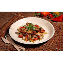 Grilované kuracie špízy s farebnou zeleninovou panvicou sa podávajú na tanieri PAPSTAR 6, palmový list „pure“ okrúhly od PAPSTAR GmbH - ekologický riad, štýlovo prezentovaný na tkanom podklade s dreveným príborom a čerstvými paprikami na dohľad.