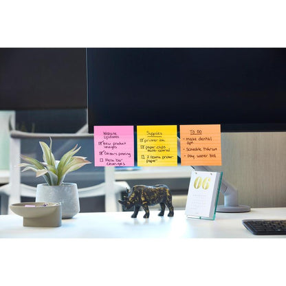 Počítačový monitor zobrazuje farebné Post-it® Super Sticky Notes vo veľkom formáte (101 mm x 101 mm, 90 listov/blok, 100% PEFC) od 3M Deutschland GmbH s aktualizáciami webových stránok, materiálom a úlohami. Na stole je rastlina, čierna figúrka slona a stolový kalendár s rokom "06".