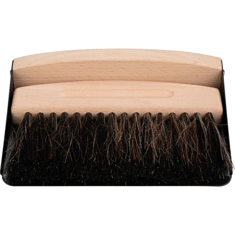 Metla s drevenou rukoväťou a tmavými štetinami sedí na čiernej lopatke - ideálna ako ENA Living stolová metlička od Abena Re-Seller GmbH (balenie 24 kusov) na jednoduché čistenie stola.