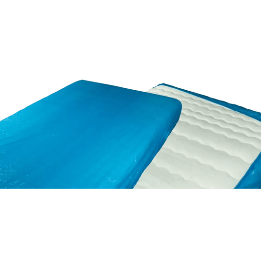 Detailný záber na modro-bielu gélovú matracovú podložku, ktorá sa podobá jednorazovému chrániču matraca AMPri MED-COMFORT PE s gumičkou o rozmeroch 210 x 90 x 20 cm od spoločnosti AMPri Handelsgesellschaft mbH. Modrá časť pokrýva väčšinu hornej plochy, zatiaľ čo biela časť má vlnitú štruktúru. Na obrázku je vidieť časť preloženú dozadu, podobne ako pri polyetylénových nemocničných chráničoch.