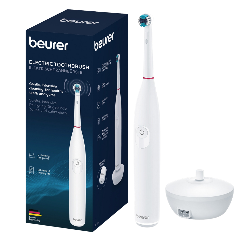 Vedľa škatule zubnej kefky sú vystavené elektrická zubná kefka Beurer TB 30 a jej nabíjacia stanica. Škatula s nápisom „Beurer GmbH“ obsahuje rôzne produktové detaily v angličtine a nemčine. Elegantná biela elektrická zubná kefka má červený akcent v blízkosti kefkového hlavice a disponuje oscilačnou technológiou pre efektívne čistenie.