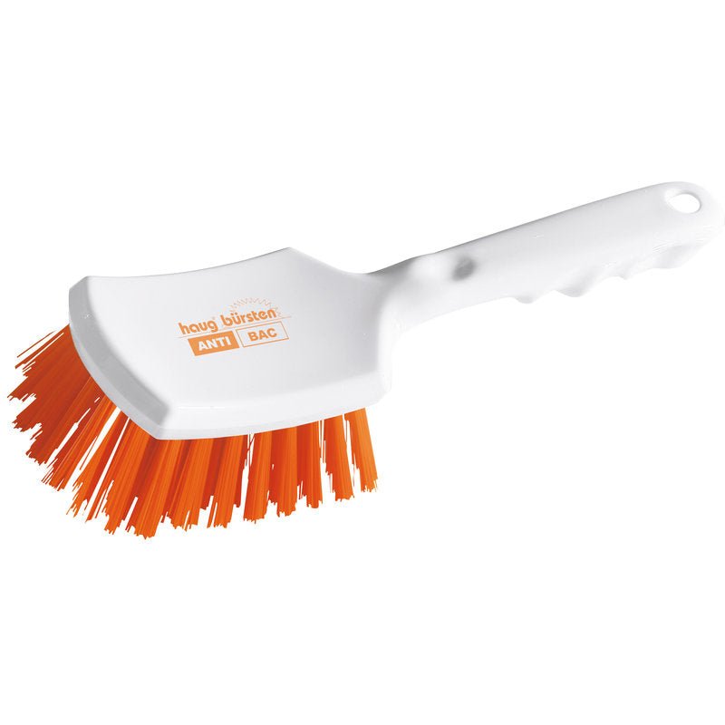 Haug Bürsten KG ANTI BAC rukoväťová kefa z bieleho plastu s mierne zakrivenou rukoväťou a tuhými oranžovými PBT štetinami (ø 0,50 mm), ktoré sú sklonené na drhnutie. Na hlave kefy sú vytlačené "ANTI BAC" a "Haug Bürsten". Veľkosť: 260x72x35mm.