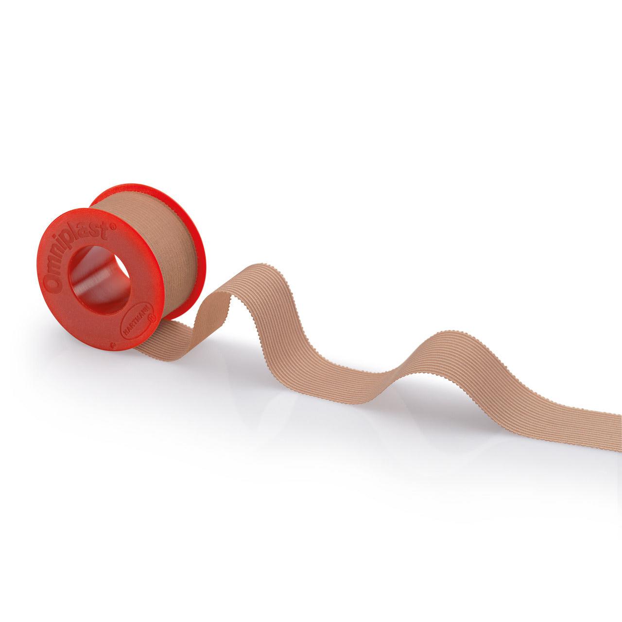 Rolka béžovej pásky Hartmann Omniplast® s červeným dávkovačom s nápisom „Paul Hartmann AG“ na bielom pozadí. Páska sa vlní smerom k pravej strane dávkovača.