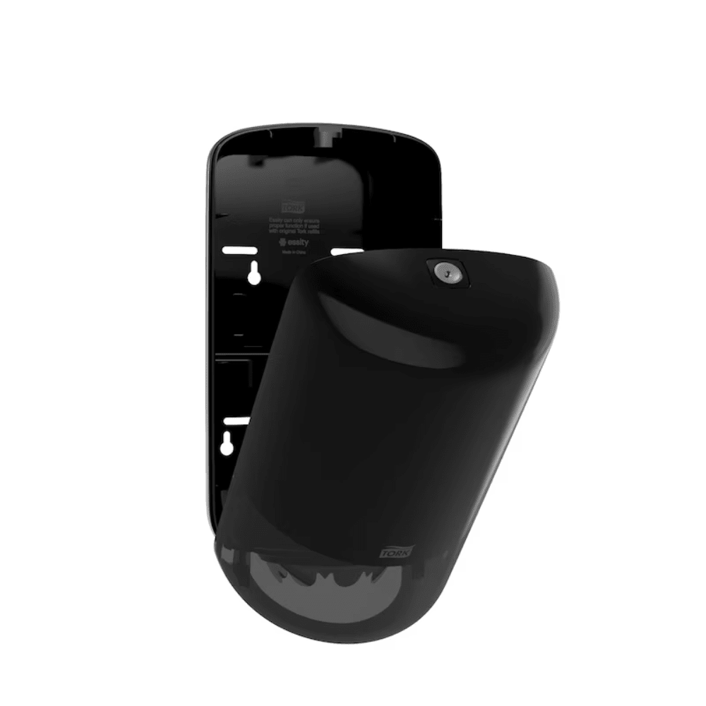 Na lesklej čiernej podstavci je upevnený dávkovač Tork 558008 Mini s vnútorným odvíjaním od spoločnosti Elevation Design by TORK – Essity Professional Hygiene Germany GmbH. Tento pohybový senzor v elegantnej čiernej farbe má spodnú časť v tvare kupoly a malý okrúhly prvok v blízkosti hornej časti. Držiak je vybavený viacerými štrbinami a otvormi, ktoré ponúkajú rôznorodé možnosti inštalácie.