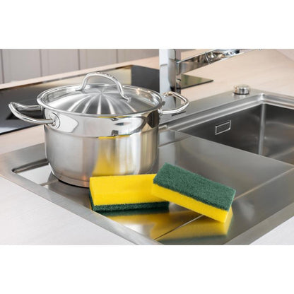 Nerezový hrniec s pokrievkou stojí vedľa umývadla. Vedľa stoja tri hubky, vrátane 3M Deutschland GmbH Scotch-Brite® Classic čistiaca hubka XXL (6 kusov na balenie). V pozadí je vidieť moderný vodovodný kohútik.