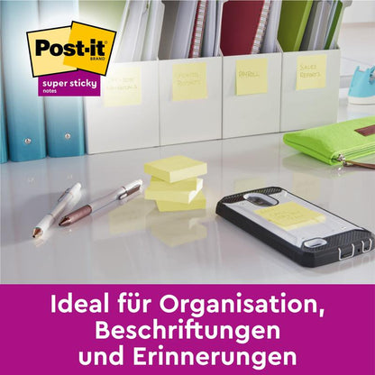 Na stole ležia perá, telefón, označené priečinky a Post-it® Super Sticky Notes (žltá, 51 x 76 mm) od 3M Deutschland GmbH. Nemecký text znie: "Ideálne pre organizáciu, označovanie a pripomienky."