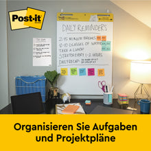 Ein Arbeitsbereich mit Stuhl, Schreibtisch, Zubehör und einer Wandtafel - ideal für die Organisation von Aufgaben und Projektplänen mit dem umweltfreundlichen Post-it® Super Sticky selbsthaftendes Recycling Meeting Chart 559RP (63,5x76,2 cm, 30 Blatt/Block).