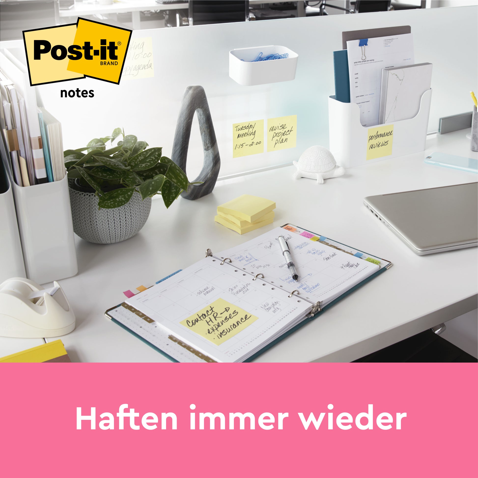 Ein moderner Bürotisch mit Schreibwaren, einem Laptop, Pflanzen und ordentlich angeordneten Post-it® Notes, Gelb (76 mm x 76 mm, 100 Blatt), von 3M Deutschland GmbH. Ein Kalender ist aufgeschlagen; auf einem rosa Balken steht in deutscher Sprache: "Haften immer wieder.